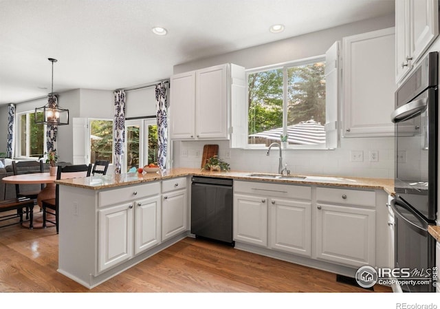 1682 Crestview Ln, Erie, CO 80516 - kitchen with dishwasher, a sink, a peninsula, white cabinetry, and decorative backsplash