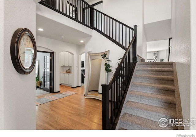 1682 Crestview Ln, Erie, CO 80516 - staircase featuring wood finished floors, arched walkways, and a towering ceiling