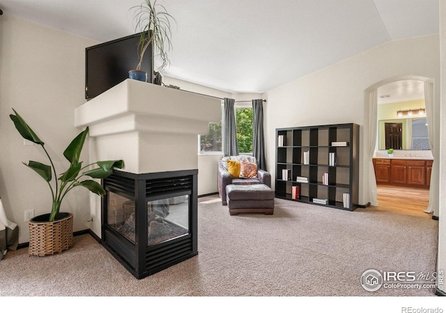 1682 Crestview Ln, Erie, CO 80516 - carpeted living area with arched walkways, a multi sided fireplace, and lofted ceiling