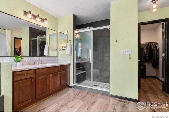 1682 Crestview Ln, Erie, CO 80516 - bathroom featuring a spacious closet, vanity, wood finished floors, and a shower stall