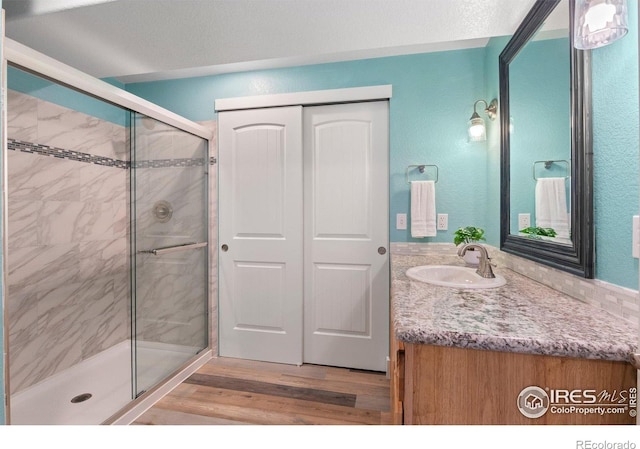 1682 Crestview Ln, Erie, CO 80516 - bathroom featuring a stall shower, wood finished floors, and vanity