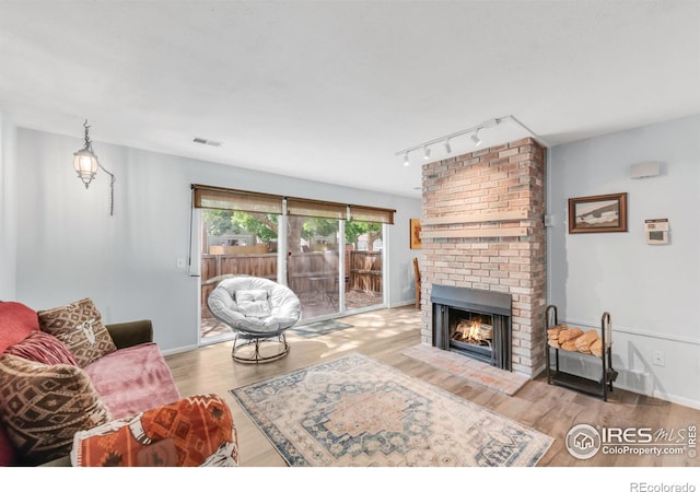 1901 W 101st Ave, Thornton, CO 80260 - living area featuring wood finished floors, track lighting, a fireplace, and baseboards