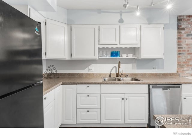 1901 W 101st Ave, Thornton, CO 80260 - kitchen with freestanding refrigerator, stainless steel dishwasher, a sink, white cabinets, and brick wall