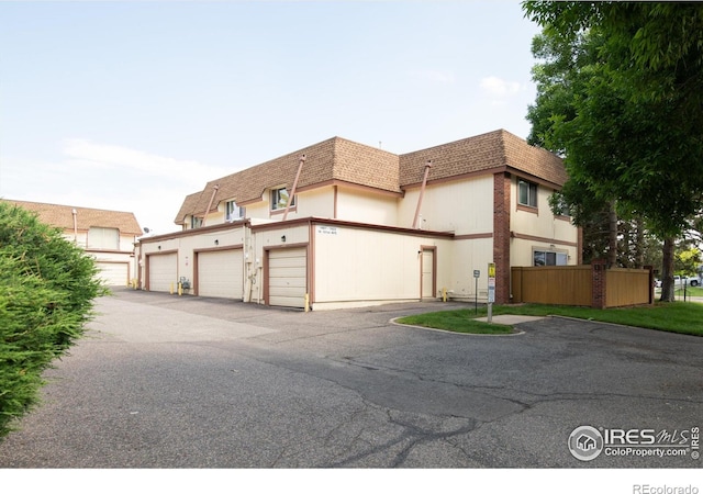 1901 W 101st Ave, Thornton, CO 80260 - view of front facade featuring mansard roof, roof with shingles, and community garages