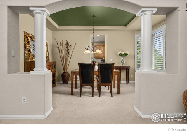 14246 Piney River Rd, Broomfield, CO 80023 - dining room featuring decorative columns, a raised ceiling, light colored carpet, and baseboards