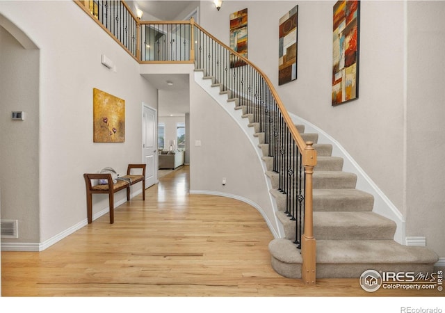 14246 Piney River Rd, Broomfield, CO 80023 - stairway with wood finished floors, arched walkways, baseboards, and a high ceiling