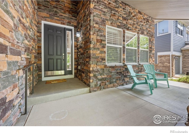 14246 Piney River Rd, Broomfield, CO 80023 - view of exterior entry with stone siding and a porch