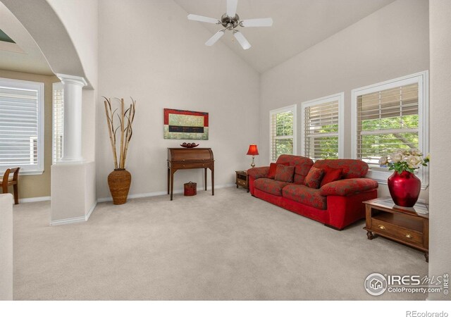 14246 Piney River Rd, Broomfield, CO 80023 - carpeted living room featuring high vaulted ceiling, arched walkways, ceiling fan, decorative columns, and baseboards