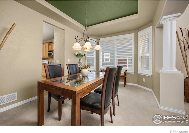 14246 Piney River Rd, Broomfield, CO 80023 - dining space featuring ornate columns, light carpet, a chandelier, and baseboards