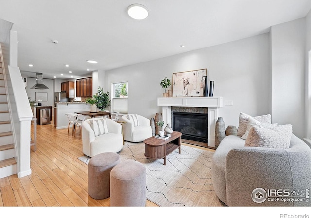4039 N Clay St, Denver, CO 80211 - living area featuring stairway, light wood-style flooring, recessed lighting, and a glass covered fireplace