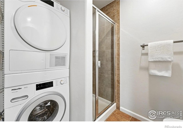 4039 N Clay St, Denver, CO 80211 - washroom with estacked washer and dryer, tile patterned flooring, and baseboards