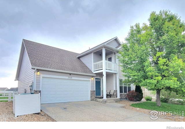 3306 Laguna St, Greeley, CO 80634 - view of front of property featuring a balcony, a shingled roof, concrete driveway, an attached garage, and stone siding