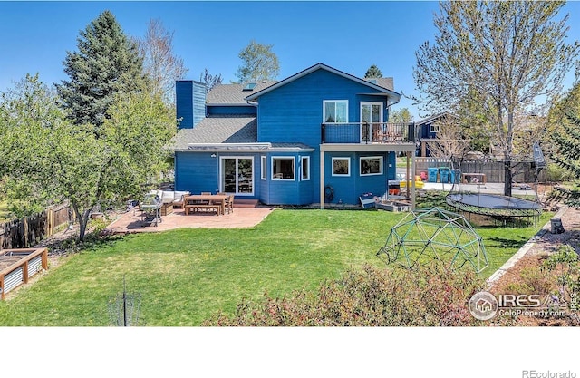 1067 W Alder St, Louisville, CO 80027 - back of property with a balcony, a chimney, a patio, and a trampoline