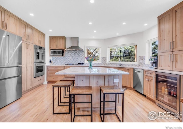 1067 W Alder St, Louisville, CO 80027 - kitchen with stainless steel appliances, wall chimney range hood, beverage cooler, light wood finished floors, and backsplash