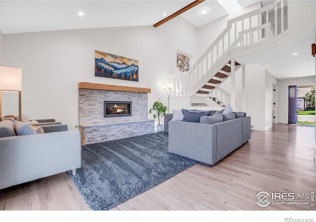 1067 W Alder St, Louisville, CO 80027 - living area with wood finished floors, stairs, high vaulted ceiling, a stone fireplace, and recessed lighting