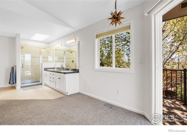 1067 W Alder St, Louisville, CO 80027 - bathroom with a skylight, vanity, a shower stall, plenty of natural light, and lofted ceiling