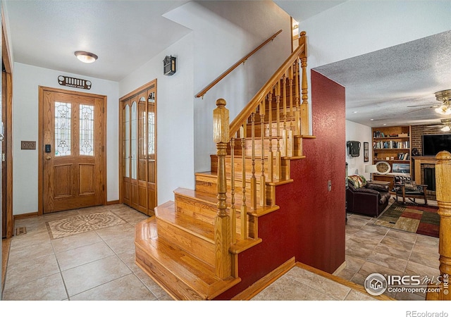 514 Palisade Mountain Dr, Windsor, CO 80550 - tiled foyer with stairs, a ceiling fan, baseboards, and a textured ceiling