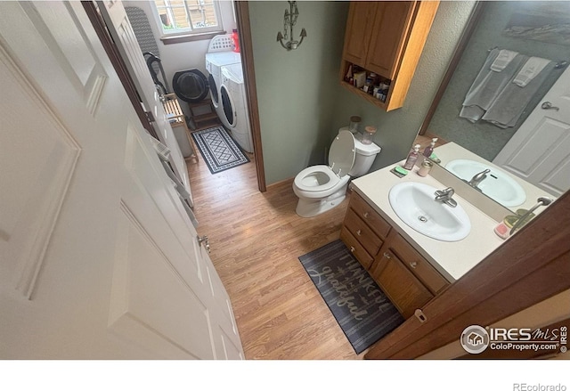 2314 42nd Avenue Ct, Greeley, CO 80634 - bathroom with washer and clothes dryer, wood finished floors, and vanity