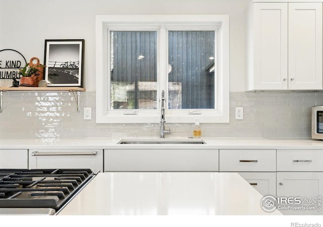 1670 Linden Ave, Boulder, CO 80304 - kitchen featuring a sink, white cabinets, tasteful backsplash, cooktop, and light countertops