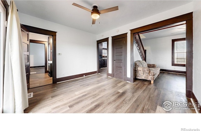 9571 Gray Ave, Carr, CO 80612 - unfurnished room with light wood-type flooring, a ceiling fan, baseboards, and stairway