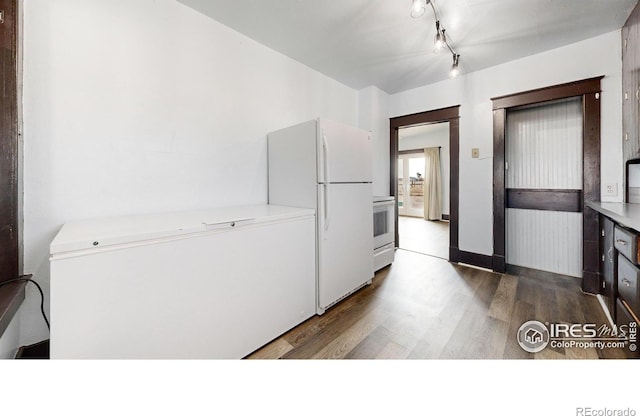 9571 Gray Ave, Carr, CO 80612 - kitchen featuring freestanding refrigerator, refrigerator, dark wood-style flooring, stove, and light countertops