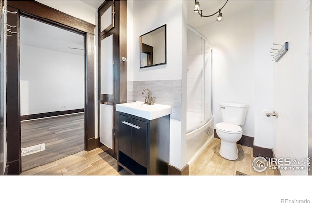 9571 Gray Ave, Carr, CO 80612 - bathroom featuring toilet, wood finished floors, vanity, and shower / bath combination with glass door