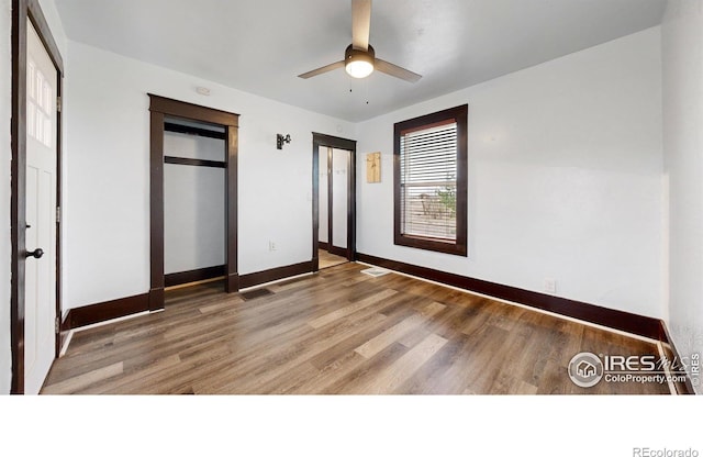 9571 Gray Ave, Carr, CO 80612 - unfurnished bedroom with wood finished floors, baseboards, two closets, and ceiling fan