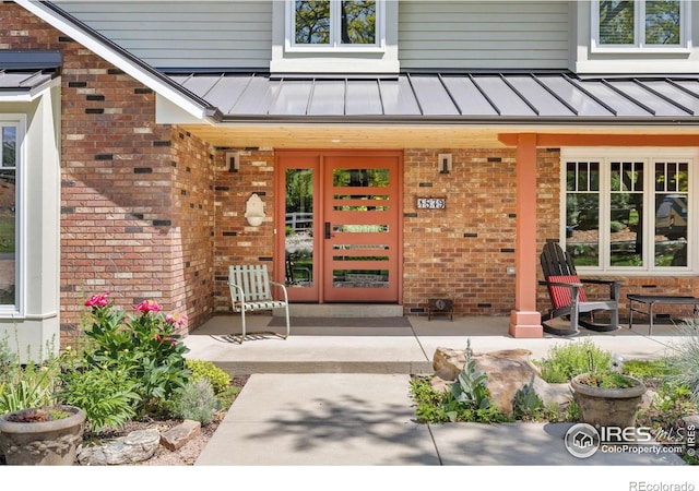 1579 W Costilla Pl, Littleton, CO 80120 - entrance to property featuring a standing seam roof, brick siding, metal roof, french doors, and a porch
