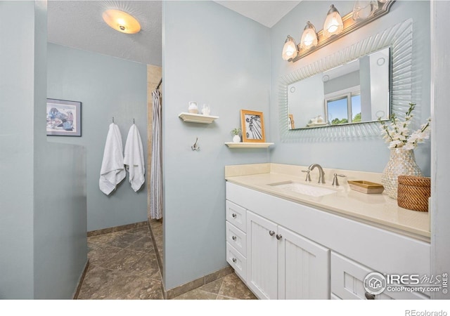 1579 W Costilla Pl, Littleton, CO 80120 - full bath featuring baseboards, vanity, stone tile flooring, and a shower with curtain
