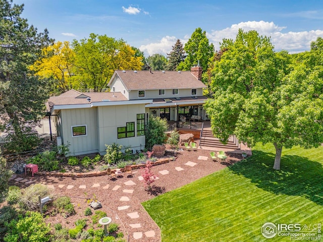 1579 W Costilla Pl, Littleton, CO 80120 - back of property featuring board and batten siding, a sunroom, a yard, a chimney, and roof with shingles