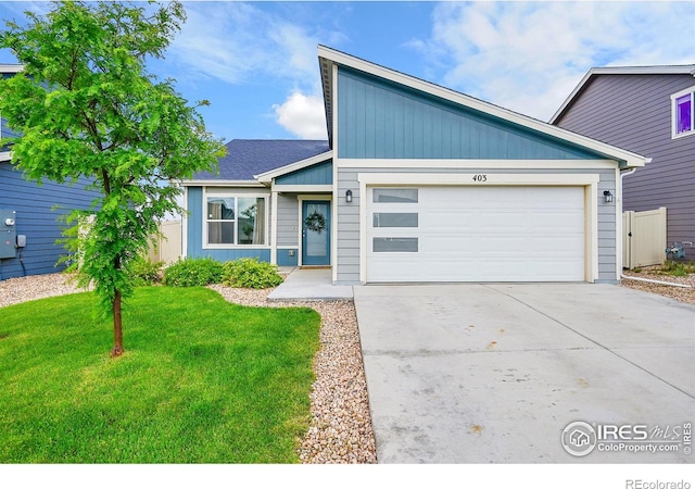 403 Pony Express Trl, Ault, CO 80610 - mid-century modern home featuring concrete driveway, a garage, and a front lawn
