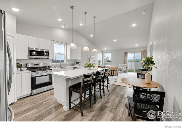 403 Pony Express Trl, Ault, CO 80610 - kitchen featuring appliances with stainless steel finishes, a kitchen breakfast bar, a kitchen island, light wood-style floors, and recessed lighting