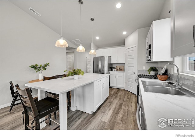 403 Pony Express Trl, Ault, CO 80610 - kitchen with a sink, stainless steel appliances, wood finished floors, white cabinets, and recessed lighting