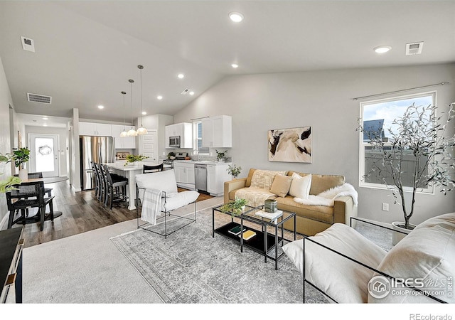 403 Pony Express Trl, Ault, CO 80610 - living area featuring vaulted ceiling, recessed lighting, and wood finished floors