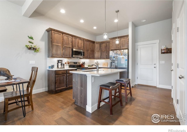 5111 Longshaw Ct Unit 5, Windsor, CO 80528 - kitchen featuring stainless steel appliances, a sink, dark wood-type flooring, light countertops, and a breakfast bar area