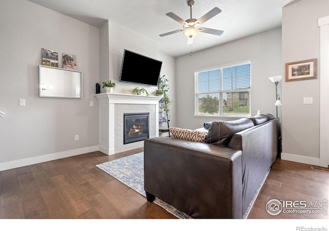 5111 Longshaw Ct Unit 5, Windsor, CO 80528 - living room featuring wood finished floors, a ceiling fan, a glass covered fireplace, and baseboards