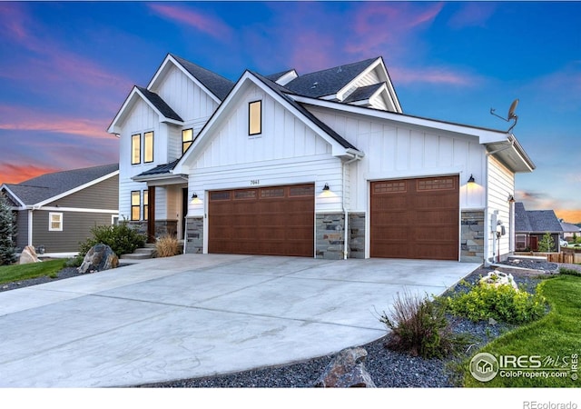 7061 Sage Meadows Dr, Wellington, CO 80549 - view of front of home with a garage, stone siding, driveway, and board and batten siding