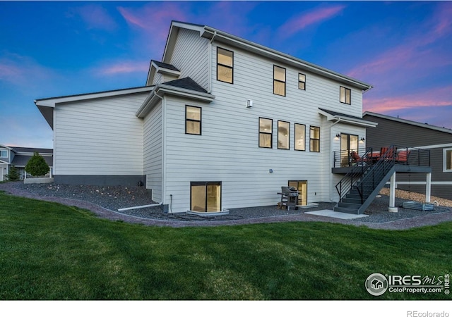 7061 Sage Meadows Dr, Wellington, CO 80549 - back of property with stairway, a lawn, and a wooden deck