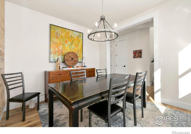 7061 Sage Meadows Dr, Wellington, CO 80549 - dining room with a chandelier, baseboards, and light wood-style floors