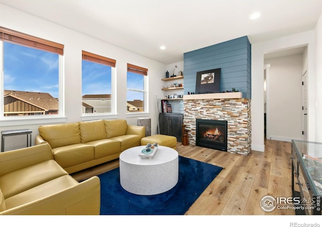 7061 Sage Meadows Dr, Wellington, CO 80549 - living area featuring wood-type flooring, a glass covered fireplace, recessed lighting, and baseboards