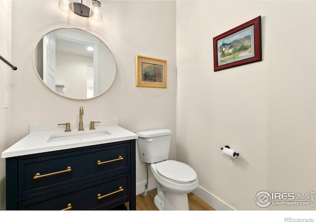 7061 Sage Meadows Dr, Wellington, CO 80549 - bathroom featuring toilet, vanity, wood finished floors, and baseboards