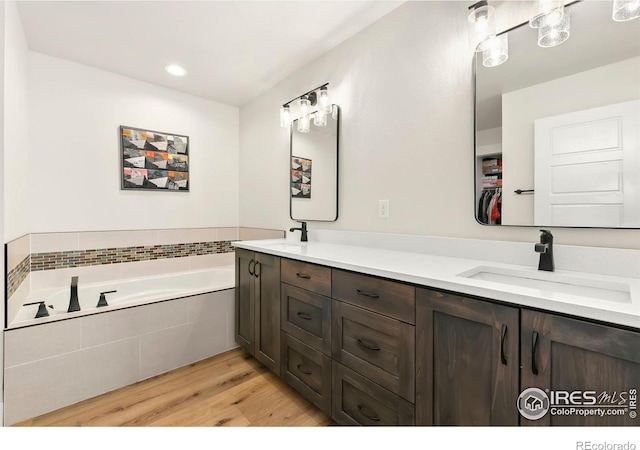 7061 Sage Meadows Dr, Wellington, CO 80549 - bathroom with double vanity, wood finished floors, a bath, and recessed lighting