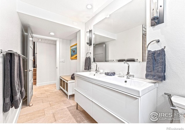 279 Green Meadow Ln, Boulder, CO 80302 - full bathroom featuring double vanity, a textured wall, recessed lighting, and toilet