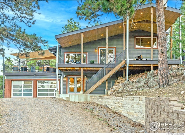 279 Green Meadow Ln, Boulder, CO 80302 - view of front of house with driveway, french doors, a deck, a balcony, and an attached garage