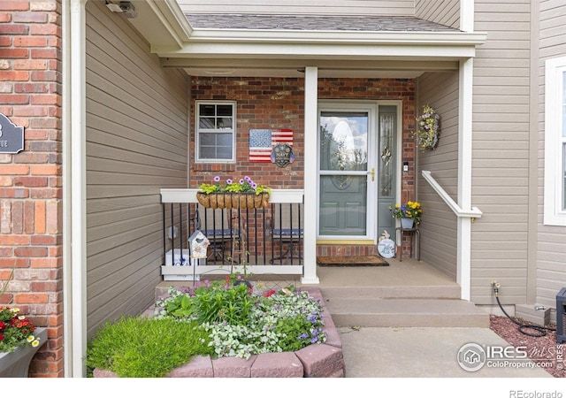 3023 39th Ave, Evans, CO 80620 - entrance to property with covered porch, brick siding, and a shingled roof
