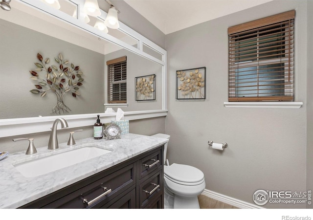3023 39th Ave, Evans, CO 80620 - bathroom with vanity, toilet, baseboards, and wood finished floors