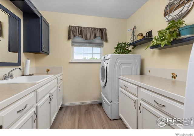 3023 39th Ave, Evans, CO 80620 - washroom with cabinet space, light wood-style flooring, baseboards, and washer / dryer