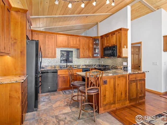 135 Canyon River Rd, Drake, CO 80515 - kitchen featuring black appliances, a peninsula, decorative backsplash, wooden ceiling, and glass insert cabinets
