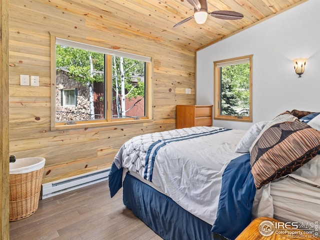 135 Canyon River Rd, Drake, CO 80515 - bedroom featuring a baseboard heating unit, wood walls, vaulted ceiling, multiple windows, and wood finished floors