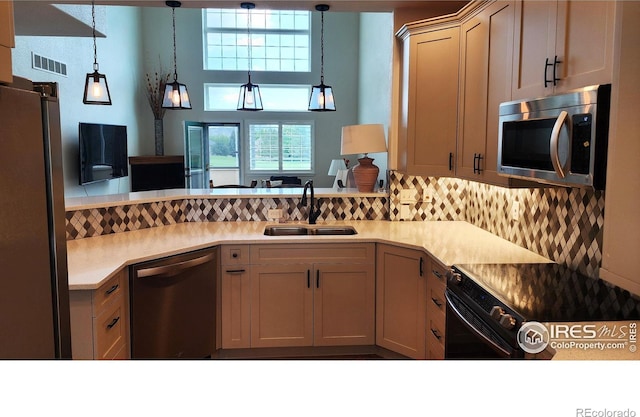 451 Clubhouse Ct, Loveland, CO 80537 - kitchen featuring appliances with stainless steel finishes, a sink, hanging light fixtures, and light countertops